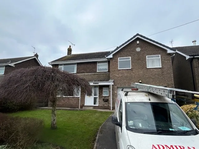 An Admiral Roofing Specialists van parked on the drive of a house with a tiled roof