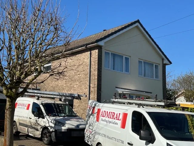Admiral Roofing Specialists vans parked outside a house with a newly tiled roof