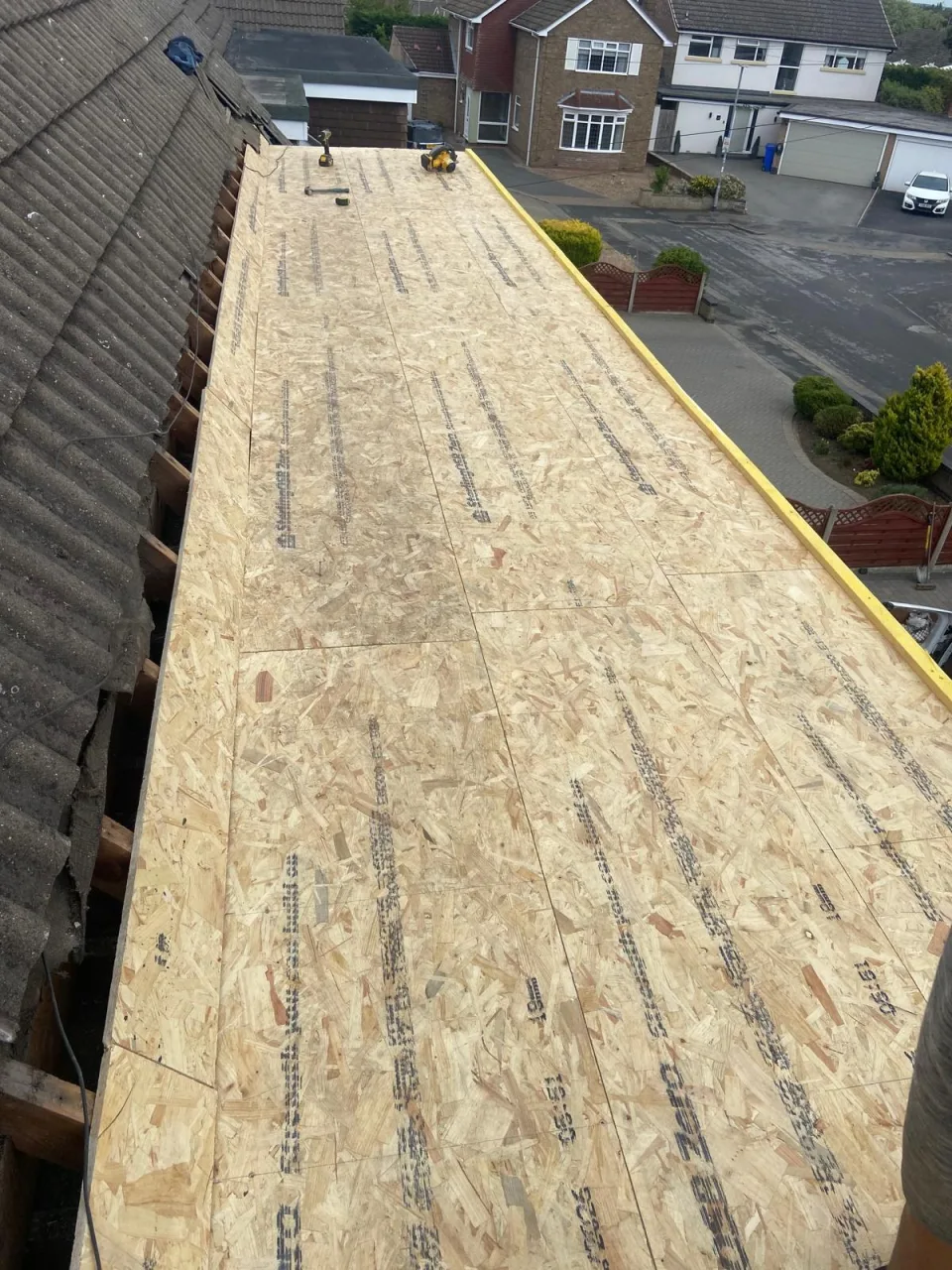 OSB boards laid across a flat roof before the new covering goes on
