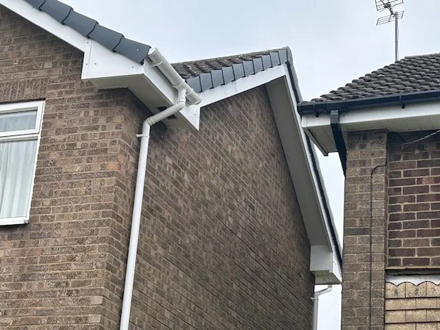 White uPVC fascia, soffit, gutter and downpipe on a brick house