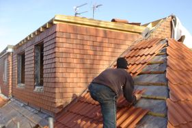 Roofer installing roof tiles